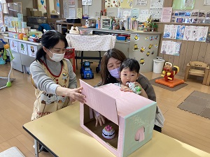 boxに手を入れて、何が入っているか当てようとする親子