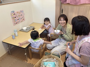 給食を食べ終えた幼児たちと栄養士に相談する母