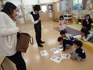 床に置かれている5枚の絵カードを子ども達が見ている写真