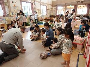 乳児の大きさの人形を使って心臓マッサージの実演を行う太田救急救命士の写真
