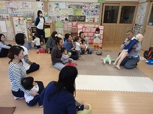 幼児の喉に異物が詰まったときの対応について人形を使いながら実践している太田救急救命士の写真