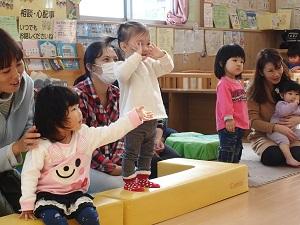 ソファに腰かけて手遊びをしている子どもや立って手遊びをしている子供の写真