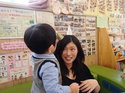 母親の頭の上に小さな三角帽子を乗せている男の子の写真