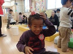 頭の上に小さな三角帽子を乗せている子供の写真