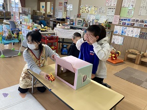 boxに車を入れる先生と、見ないようにする親子