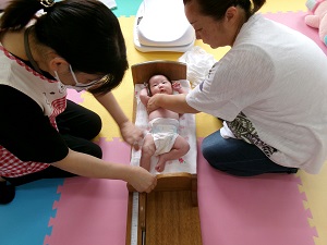 身長を測る乳児