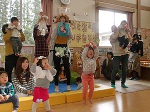 両手を挙げてジャンプしている女の子、お家の人に両脇を抱えられ上に持ち上げてもらっている子ども達の写真