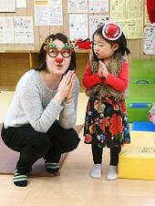 赤い帽子を被った女の子とトナカイの眼鏡をかけた女性が両手を合わせたボースをしている写真