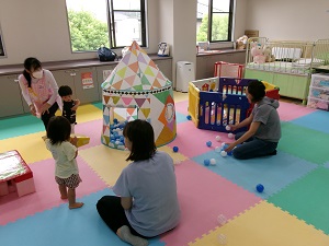 ボールプールを囲んで遊ぶ親子たち