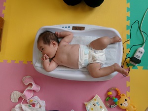 体重を測る乳児