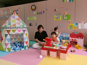 ボールプールの側でおままごとをする親子