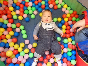ボールプールに寝転ぶ乳児