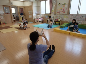 リトミック講師と親子が手遊びをしている