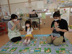 お祝いされる女児と乳児