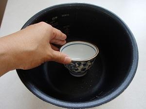 炊飯器の釜の中に湯呑を入れている写真