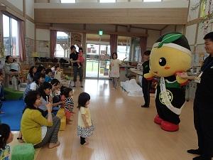 「もろ丸くん」と関係者の方々が参加者の親子の皆さんの前に立って話をしている写真