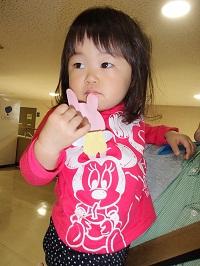 ピンクのシャツを着た女の子がウサギのメダルを持っている写真