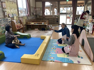 手話の先生と一緒にぞうさんの手話をする親子