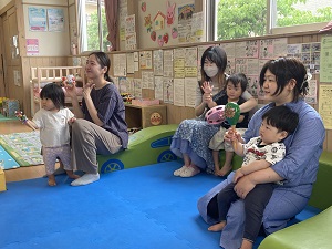 お歌に合わせて鈴を鳴らす親子たち