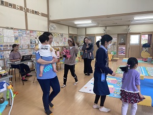 先生が弾くピアノに合わせて歩く親子たち