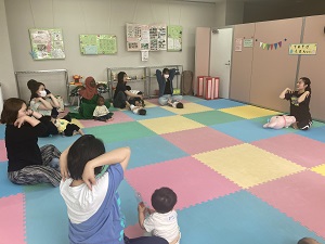 肩まわりの運動をする先生と親子たち