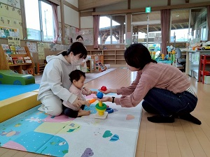ボールやリングで色遊びをする先生と親子