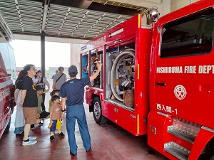 消防車の説明を聞く親子たち