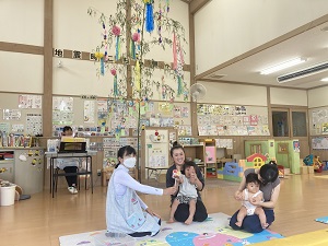 七夕飾りの下でお誕生日をお祝いされる親子たち