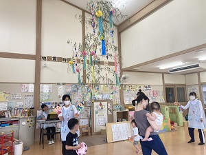 七夕の歌にあわせて鈴を鳴らして歩く親子たち