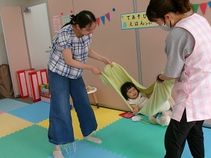 タオルブランコをする親子と先生