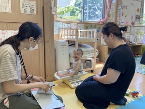 体重を測る乳児