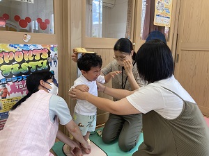 身長を測る幼児と保健師たちの様子