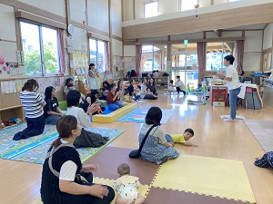 英語を話す先生と、それを聞く親子たち