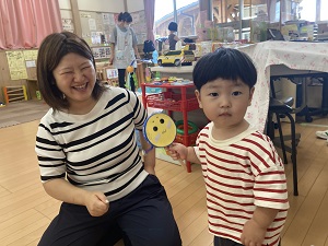 作ったばかりのでんでん太鼓を持つ幼児