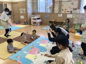 レースをする乳児たちと声をかける母たち