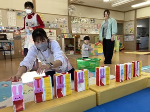 牛乳パック制作の説明をする先生