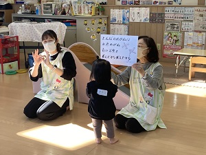 手話をする先生と見に来た幼児