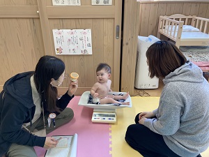 体重を測る乳児