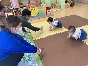 はいはいレースをする親子たち