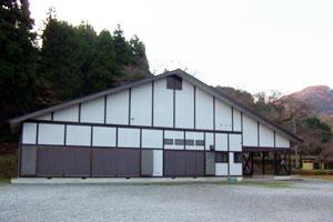 三角屋根に外壁が白色とグレー色の木造の「もろびとの館」の外観写真