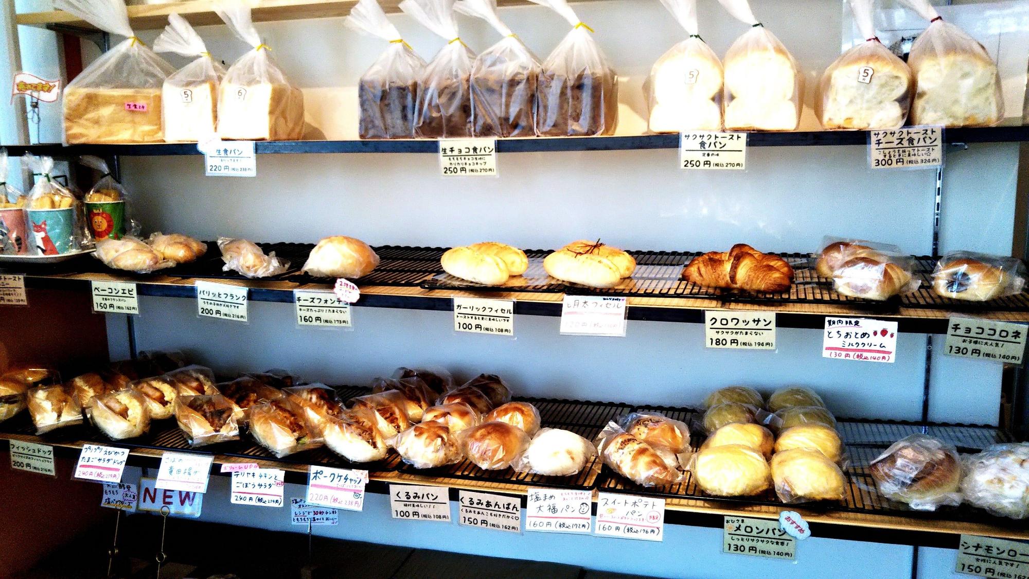 棚に食パン、クロワッサン、メロンパンなどたくさんの種類の手作りパンが並んでいる店内の写真
