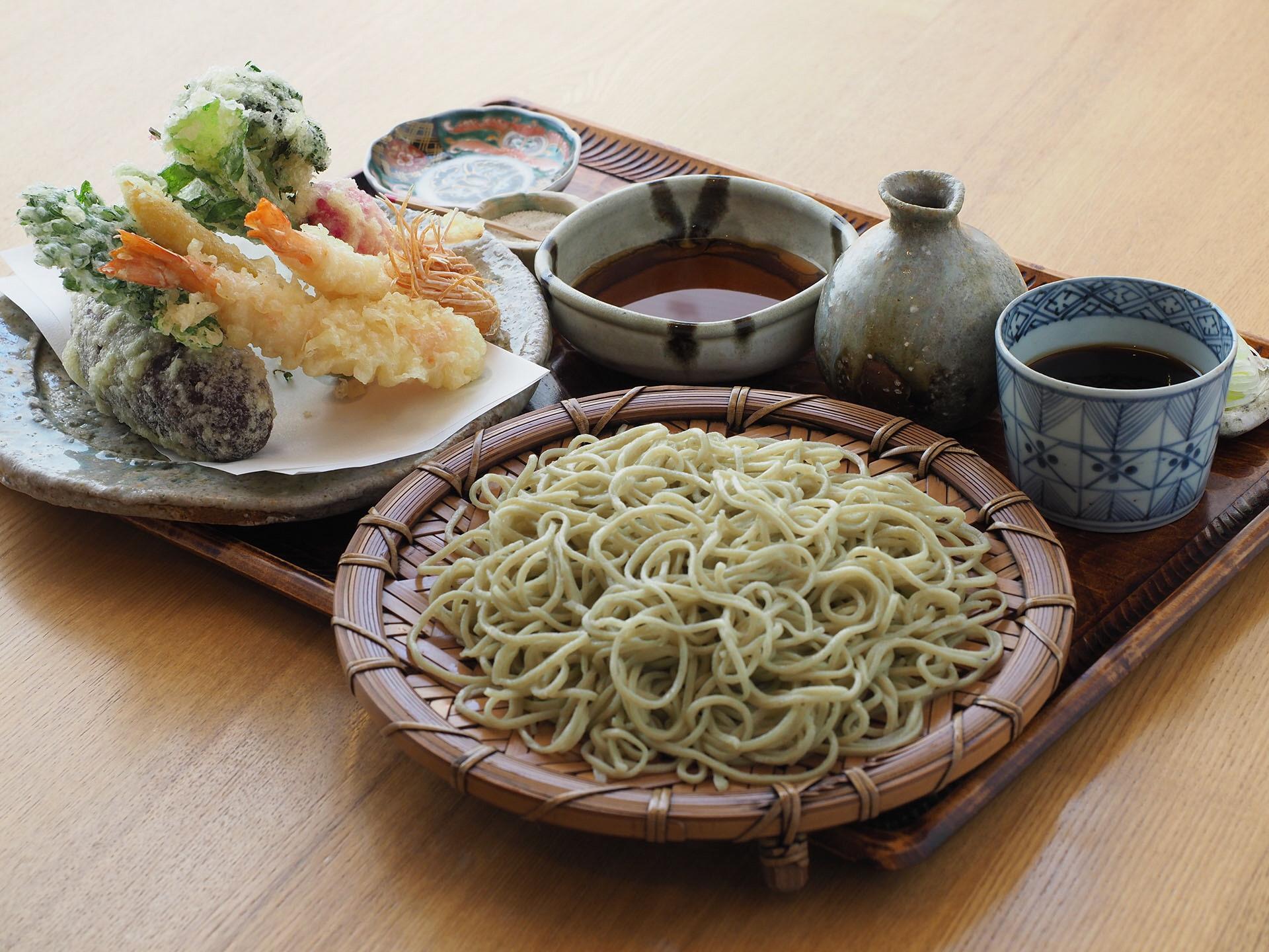 ざるに盛られた蕎麦、お皿に盛られたエビや野菜の天ぷら、つゆが一緒にお盆に盛られている写真