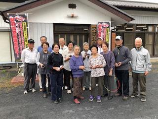 沢田公会堂の玄関前で、講師の方と軽スポーツ出前講座を受講された合計13名の男女の集合写真