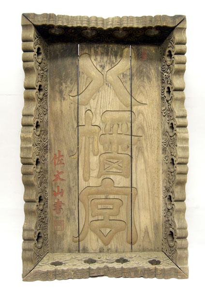 「八幡宮」の文字が隷書体で彫り出された木製で長方形の扁額の写真
