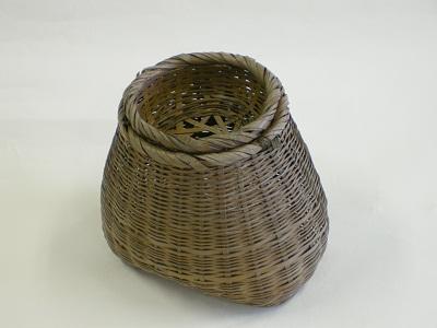 細く割いた竹で編まれた捕った魚を入れる魚籠の写真