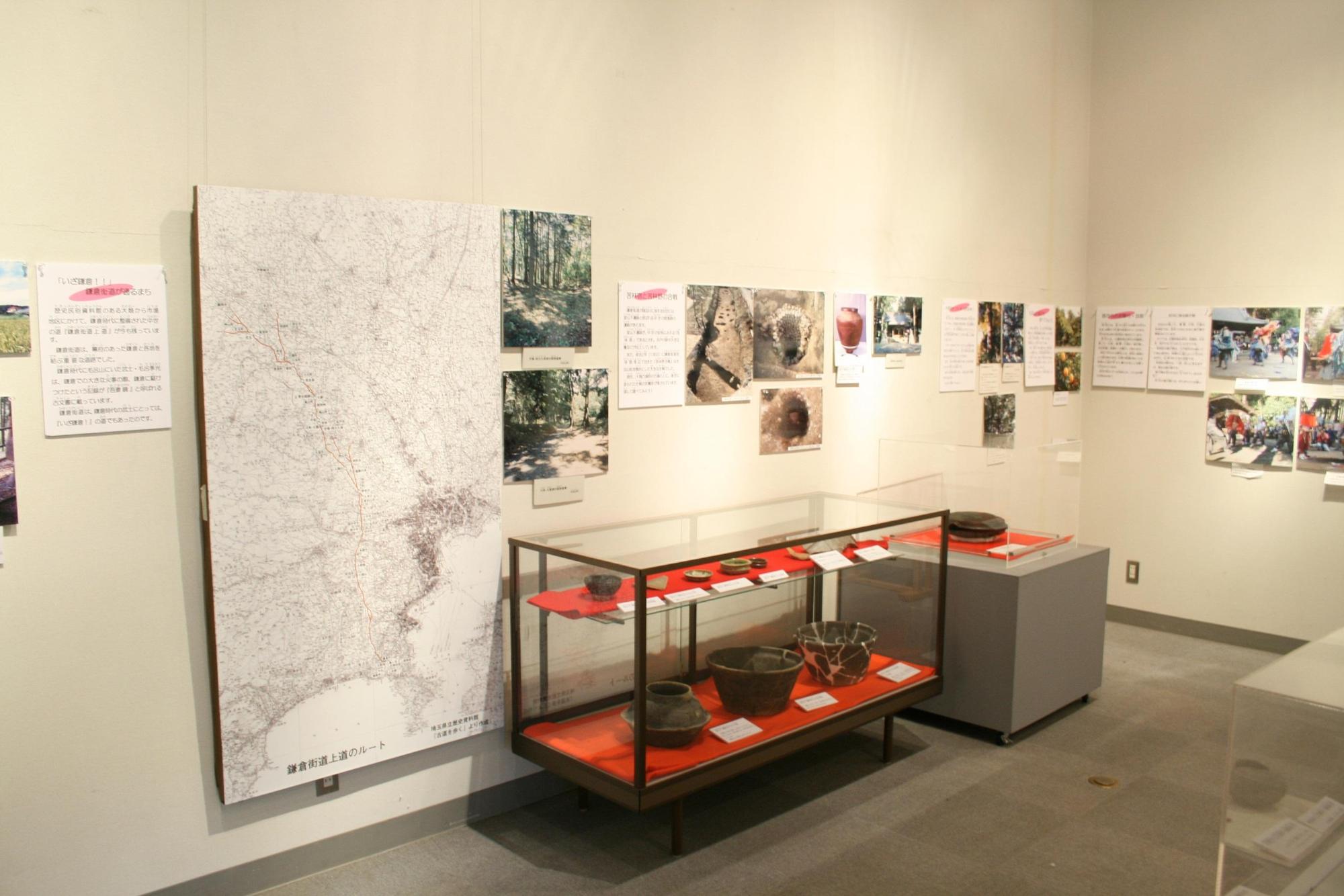壁に大きな街道地図や写真、手前のショーケースに様々な形の土器や発掘品などが展示されている写真