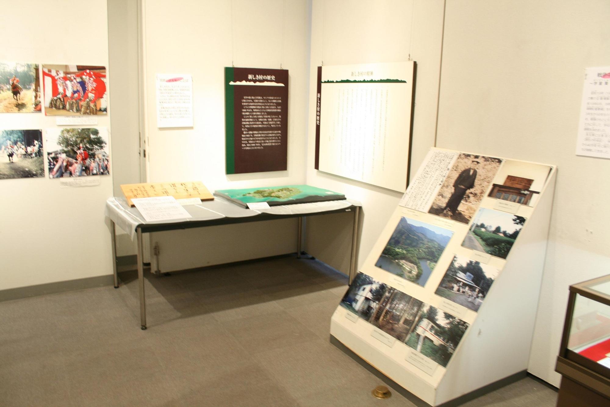 奥の壁に説明書き、手前の大きなテーブルの上に展示品、右側壁沿いに様々な写真が展示されている武者小路実篤のコーナーの写真