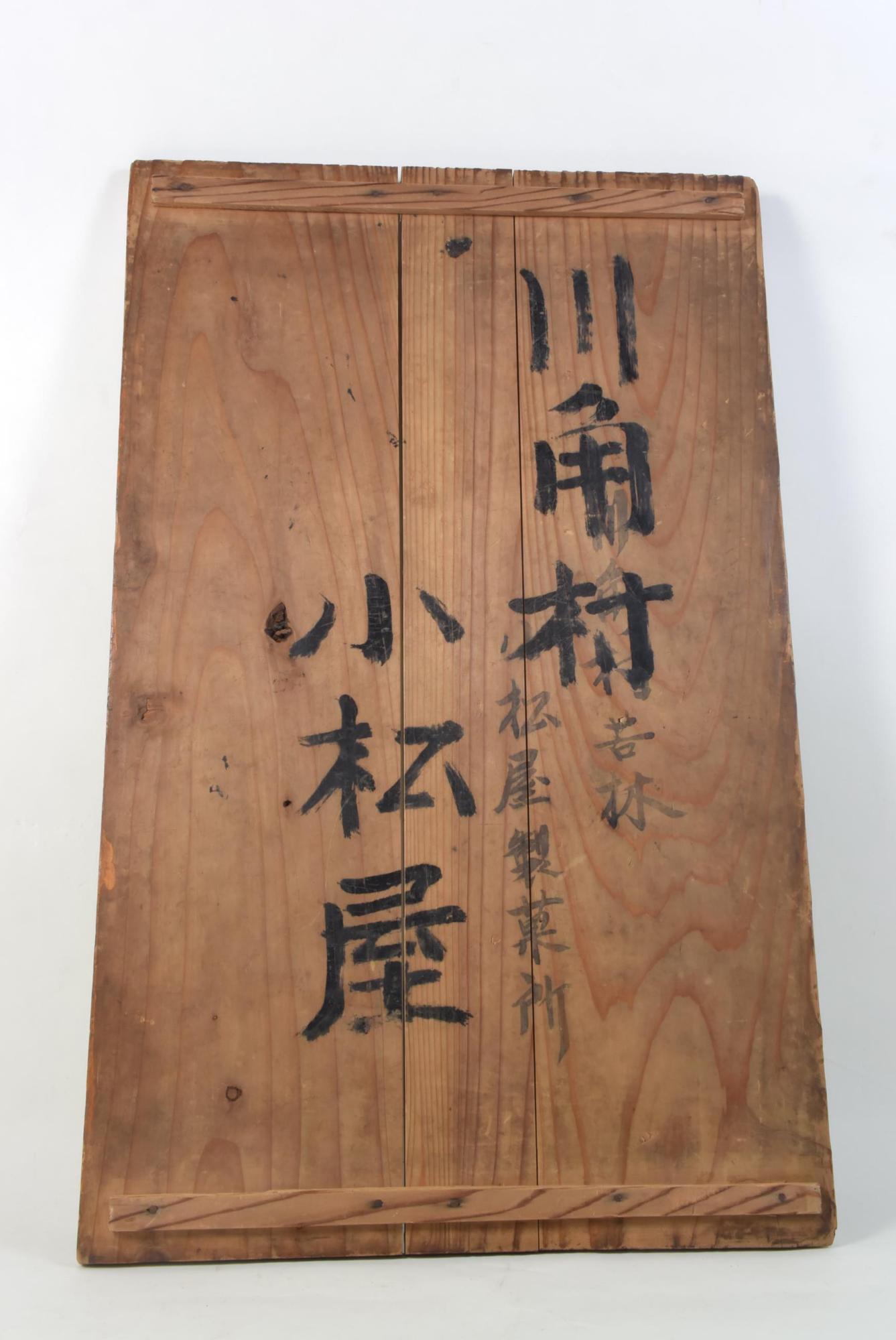「川角村 苦林 小松屋製菓所 小松屋」の文字の墨書がある菓子箱の蓋の写真