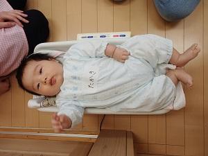 ベビー用体重計に寝かされている赤ちゃんの写真