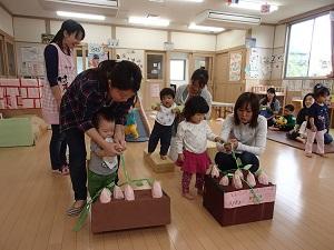 子供がお母さんと一緒に、手作りのブドウを引っ張る写真